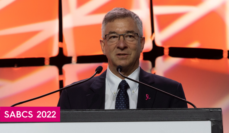 bcrf investigator dr. david rimm speaks at a podium at sabcs 2022 with an orange background behind him