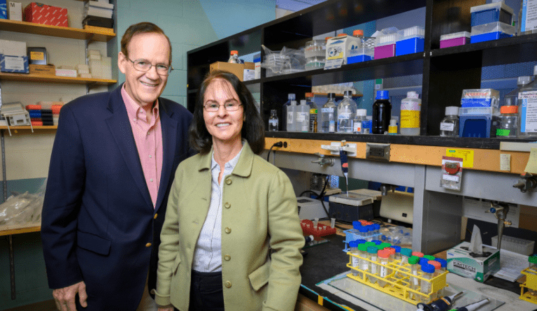 john and benita katzenellenbogen stand side by side in their lab