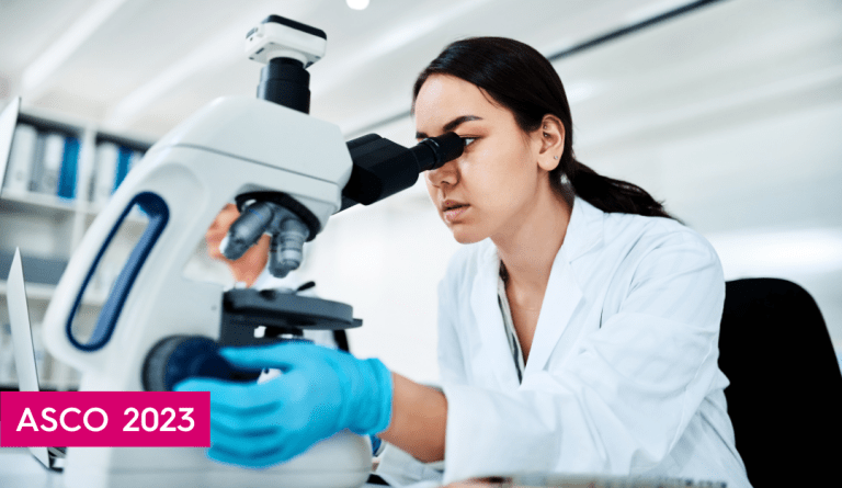 an asian woman wearing a lab coat looks at a microscope wearing blue gloves