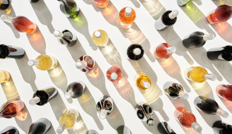 An overhead shot of several bottles of wine against a white backdrop