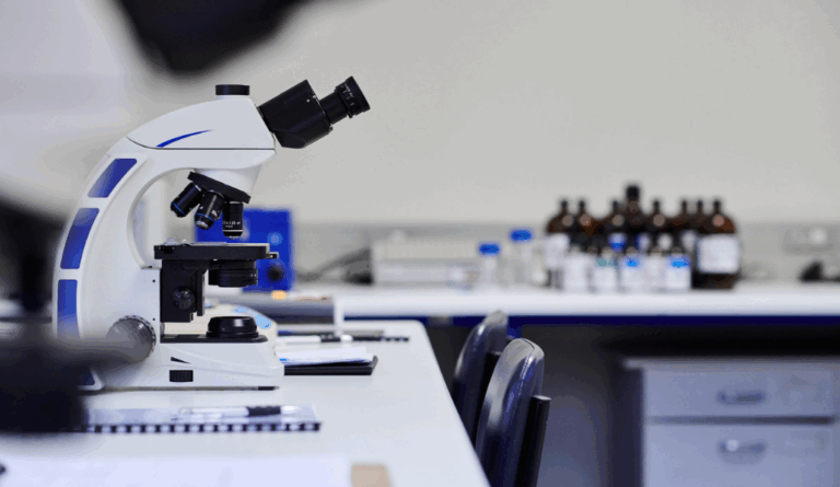 a microscope sits in an empty lab, evokes cuts to breast cancer research funding