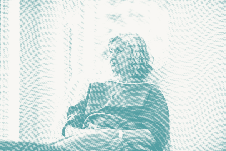 an older woman wearing a hospital gown waits for a lumpectomy