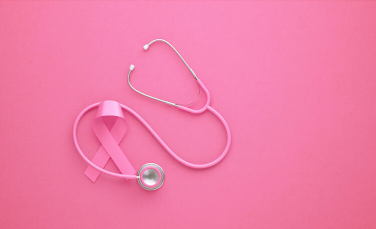 A pink ribbon is interspersed with a pink stethoscope against a pink background