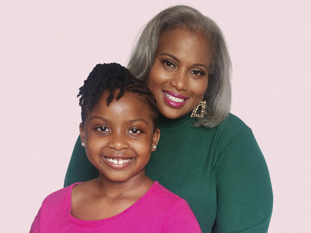 A woman and her daughter smiling.