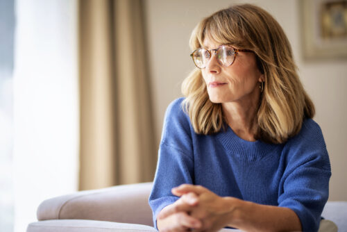 A woman wearing a blue shirt looks off into the distance.