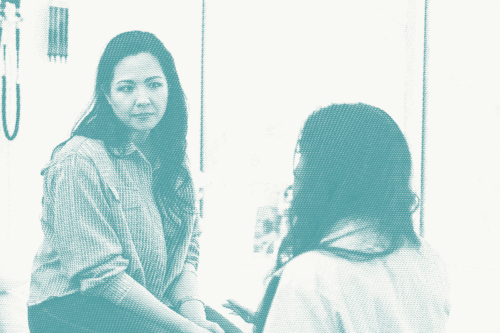 A woman talking to her doctor. She has a concerned expression