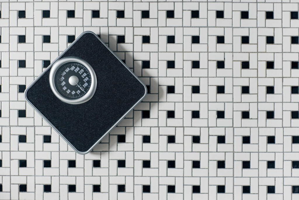 A bathroom scale on a tiled floor