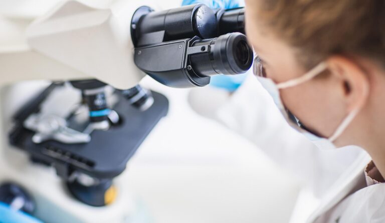 A female scientist looking into a microscope
