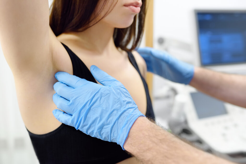 Doctor mammologist examines woman breasts and lymph nodes
