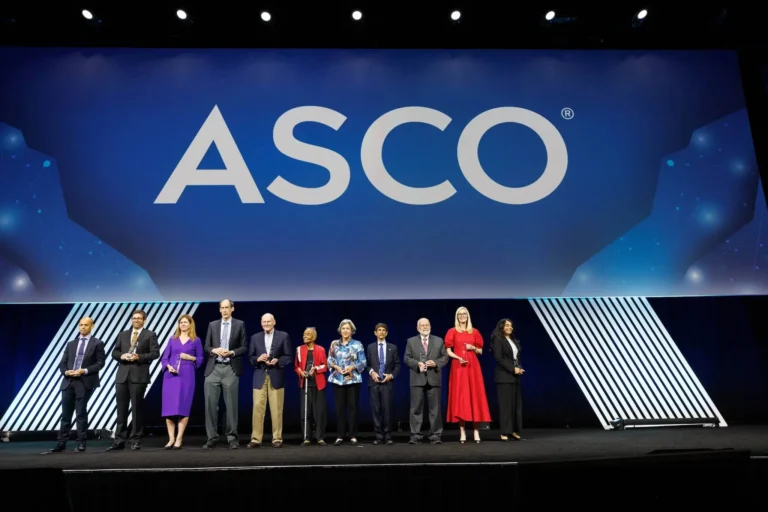 ASCO awardees standing in front of an ASCO sign