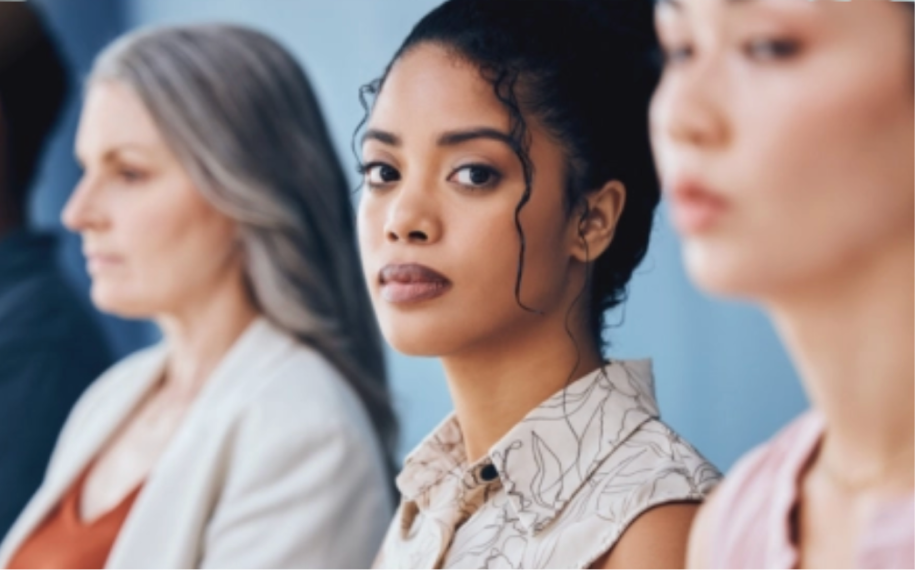 three women in a line, young woman in the middle looking at the camera