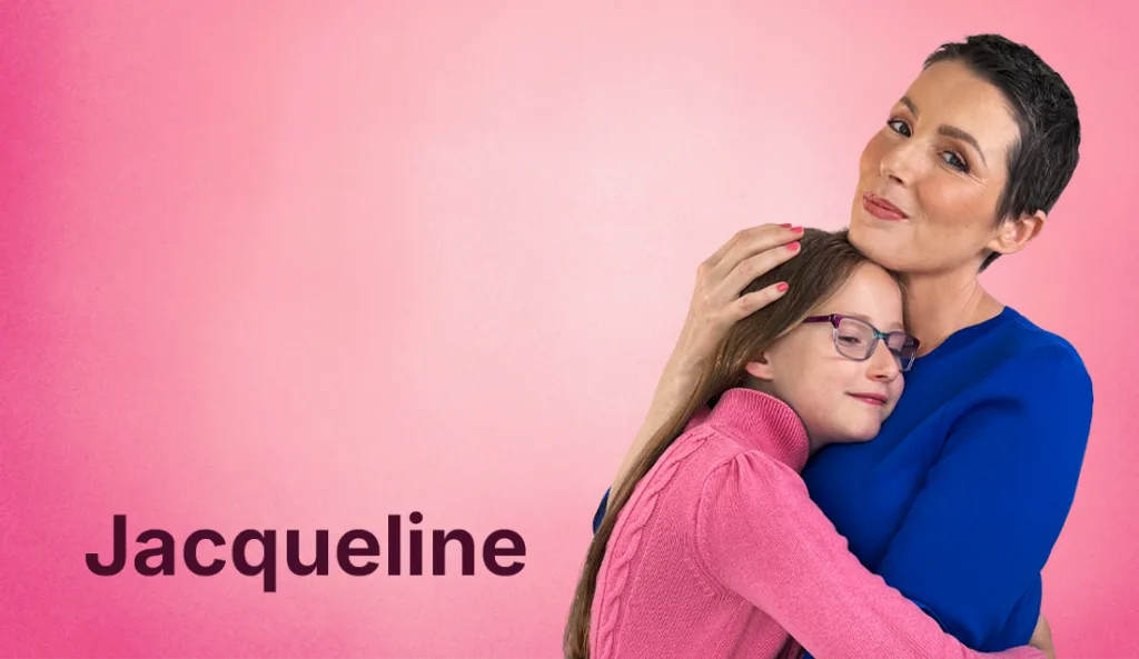 Jacqueline and her daughter hugging in front of a pink background and her name on the bottom left of the photo